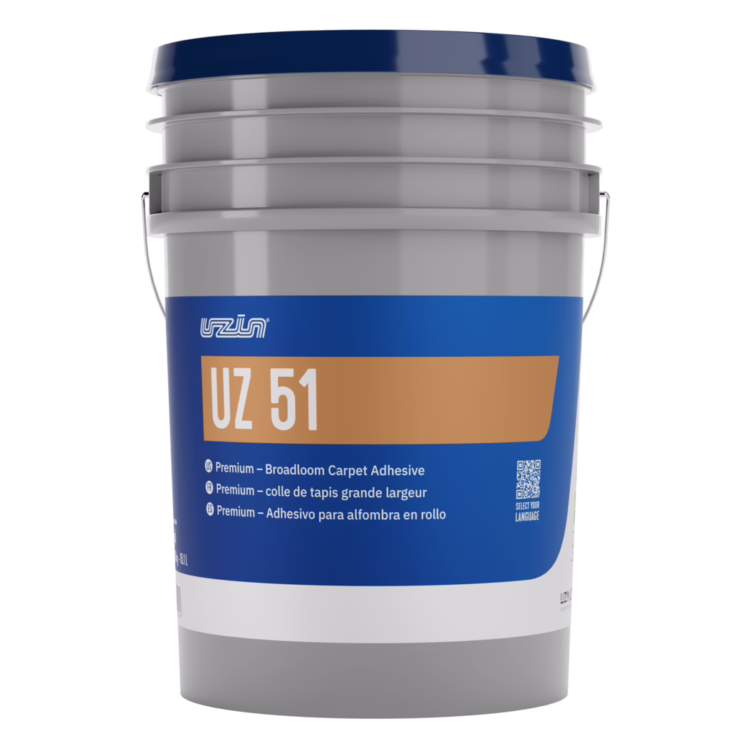 Close-up studio photograph of the upper section of a large plastic product bucket used for adhesives or coatings. The image shows a glossy dark blue lid seated on a light gray, ribbed bucket neck with stacked reinforcement rings. A metal bail handle is partially visible at the bucket sides. A deep blue label wraps the body and features a tan rectangular panel with the white text 'UZ 51' and a small white logo above it; below are several short multilingual descriptions and a QR code. The plastic surface reflects soft studio highlights and the composition is tightly cropped against a bright white background, emphasizing the container's form, texture and printed branding.